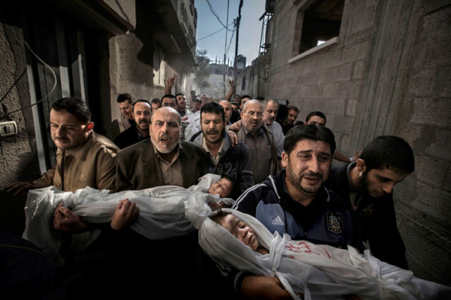 Mourners carry the bodies of a brother and sister
